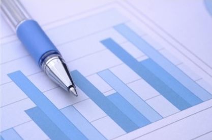 Silver and light blue pen on top of a set of bar charts